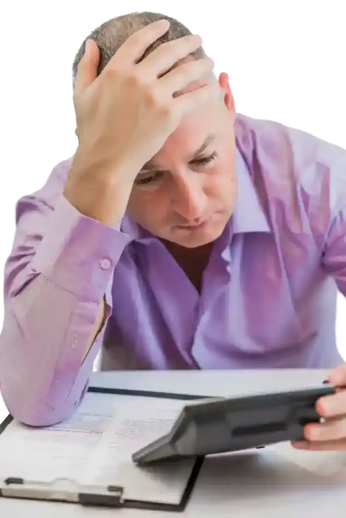 a man holding his head looking at a tablet